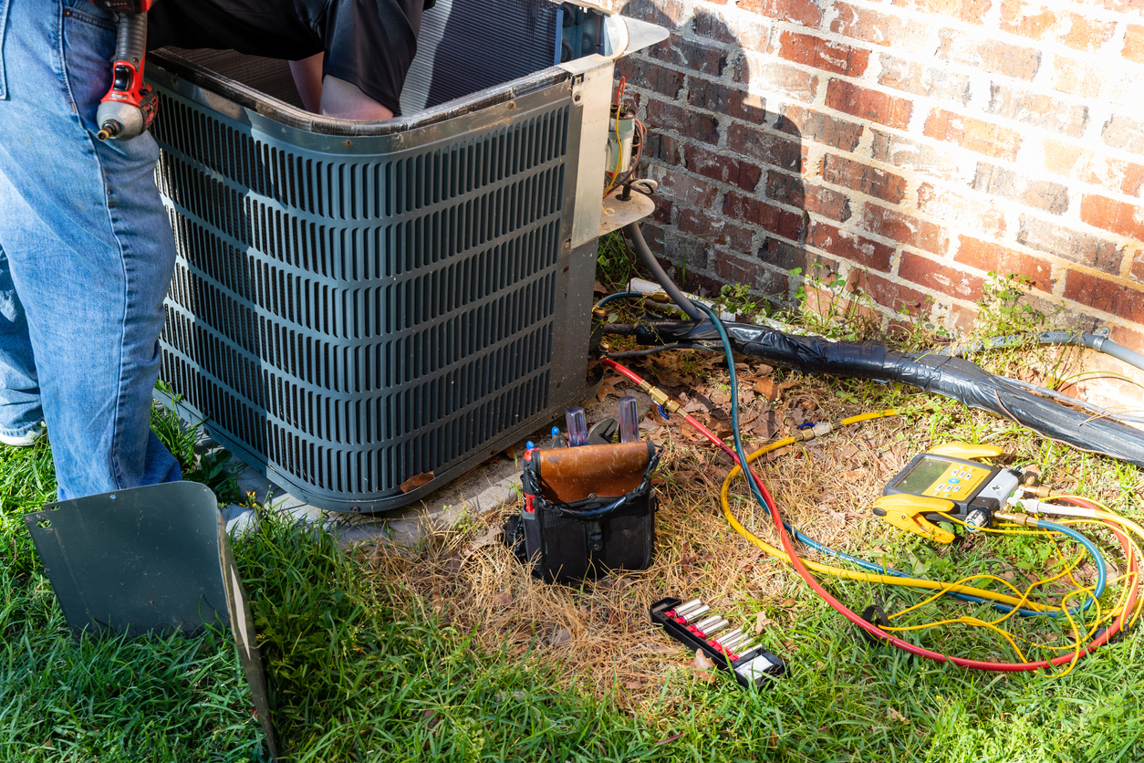 HVAC technician performing a maintenance service on an AC unit