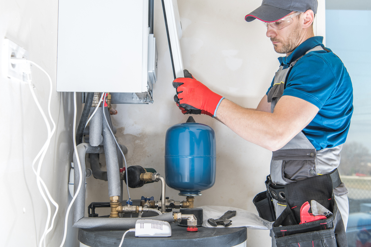 HVAC technician installing a heating system in a residence