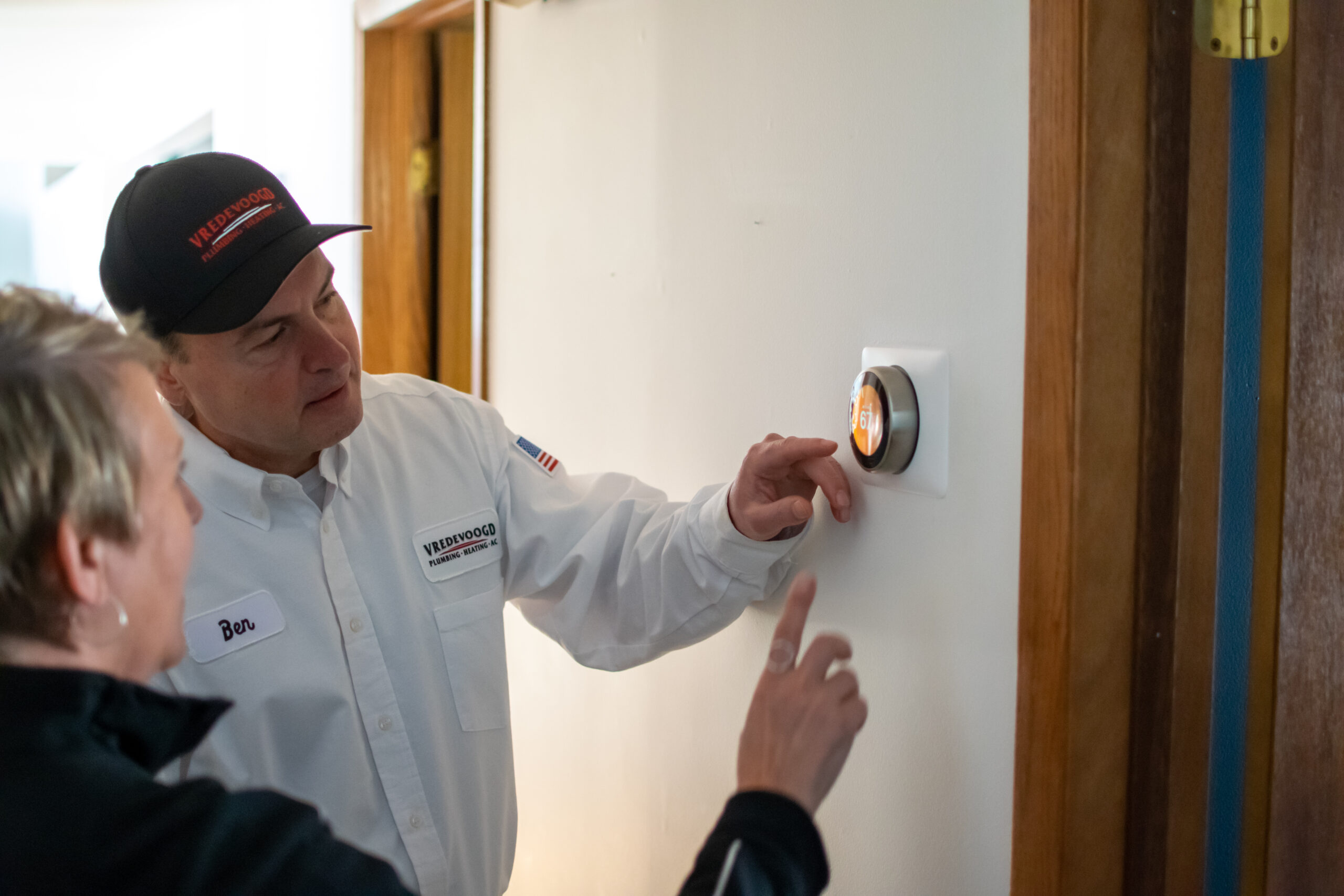 Vredevoogd technician speaking with a homeowner about a newly installed thermostat