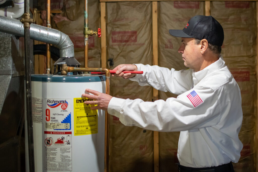 Plumber repairing a hot water heater in Coldwater Michigan